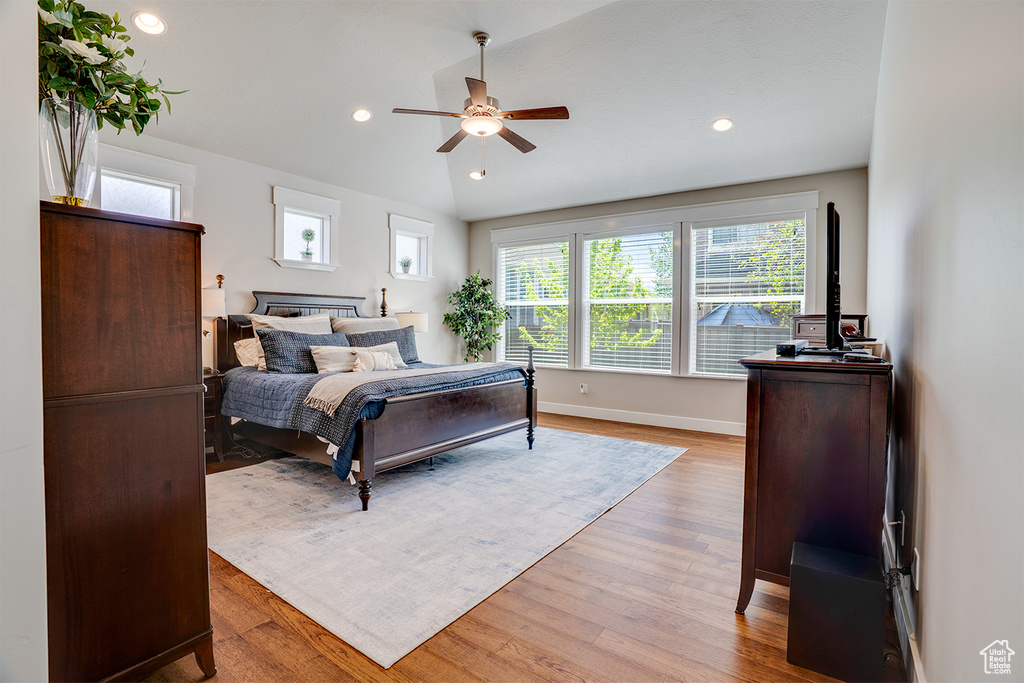 Bedroom with lofted ceiling, recessed lighting, light wood finished floors, baseboards, and ceiling fan