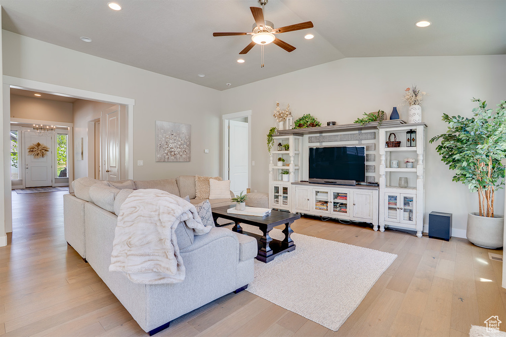 Living area featuring ceiling fan, light wood-type flooring, recessed lighting, a chandelier, and vaulted ceiling