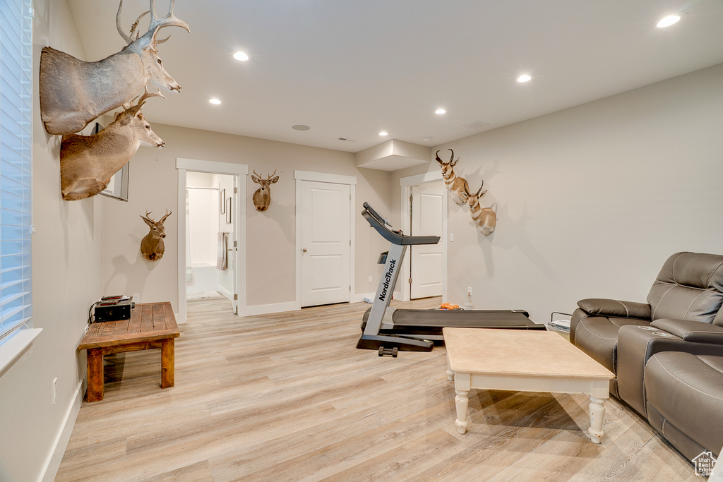 Exercise area with baseboards, recessed lighting, and light wood-style flooring