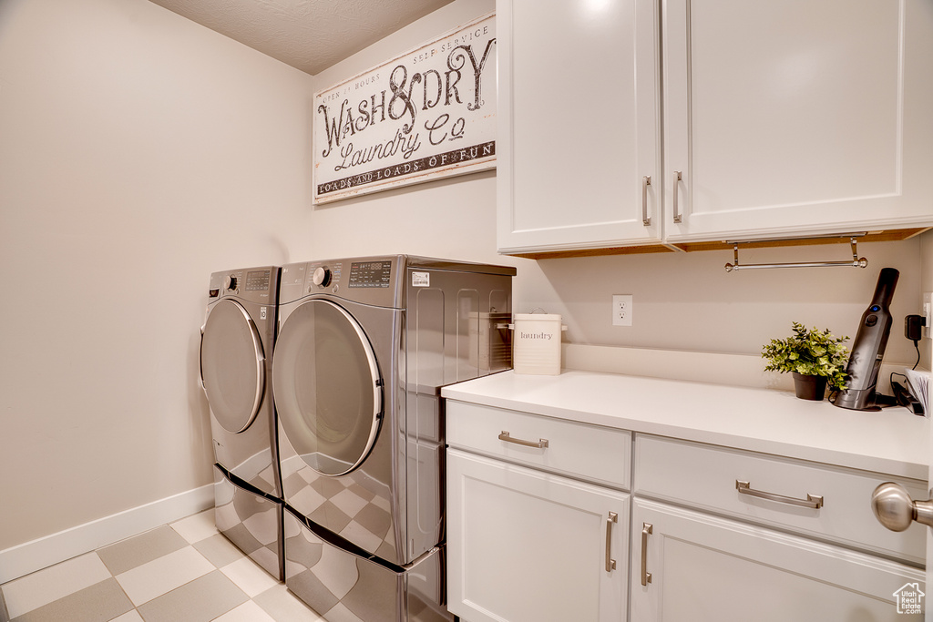 Laundry room with independent washer and dryer, cabinet space, tile patterned floors, and baseboards