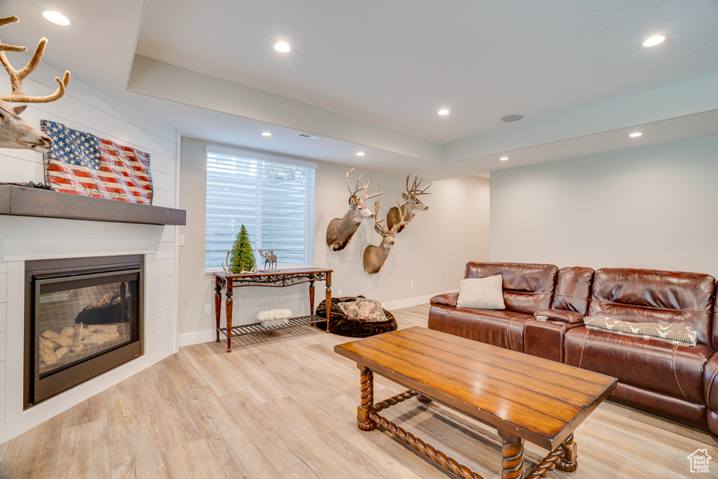 Living area featuring light wood-style floors, recessed lighting, a large fireplace, and baseboards