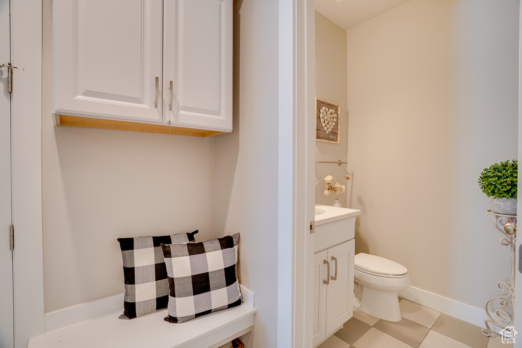 Half bath with toilet, vanity, and baseboards