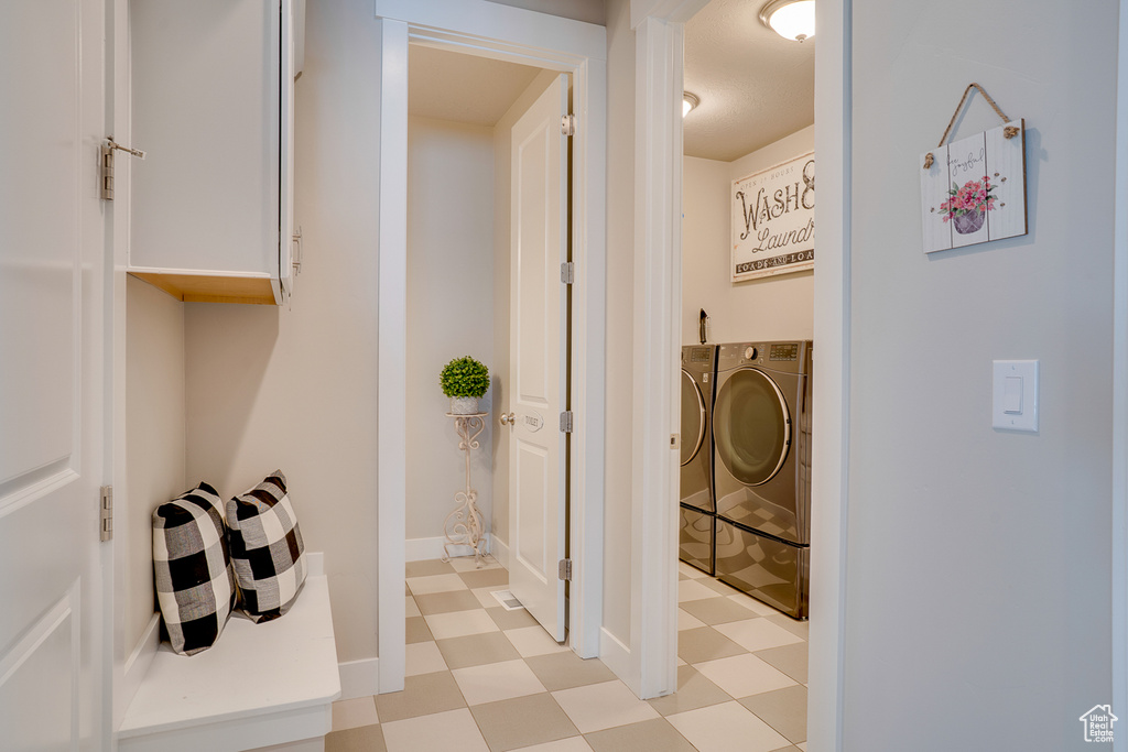 Bathroom featuring washing machine and clothes dryer and tile patterned floors