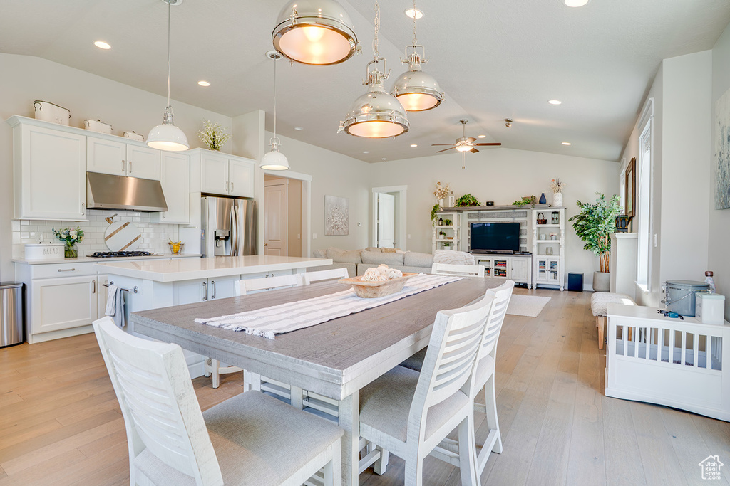 Dining room featuring vaulted ceiling, ceiling fan, light wood-style flooring, and recessed lighting