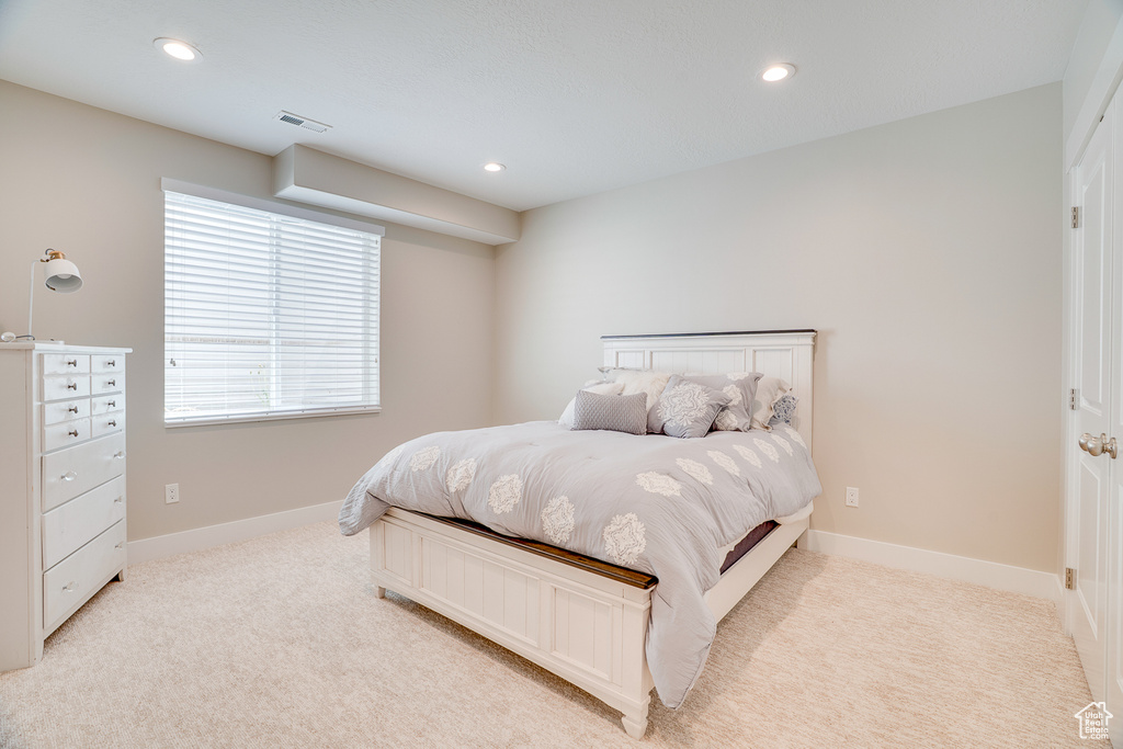 Bedroom with light carpet, recessed lighting, and baseboards
