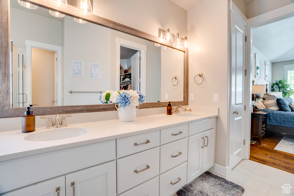 Full bath with ensuite bathroom, double vanity, and tile patterned floors