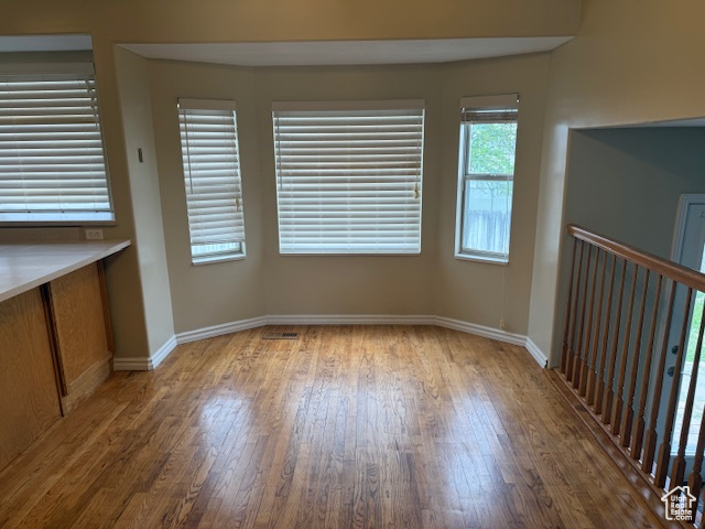 Unfurnished dining area with wood finished floors and baseboards