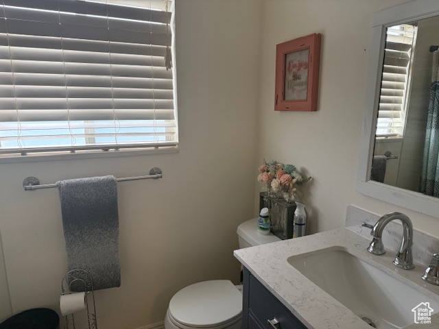 Full bath with plenty of natural light, toilet, and vanity