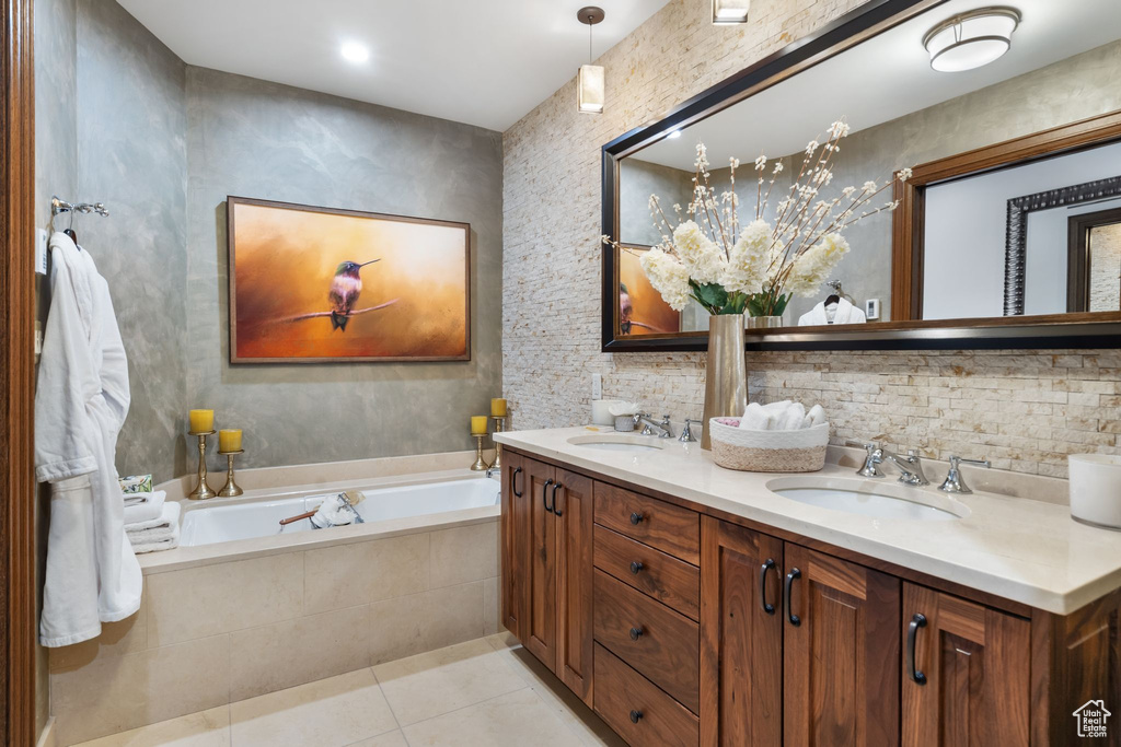 Bathroom with tile patterned flooring, a garden tub, and double vanity