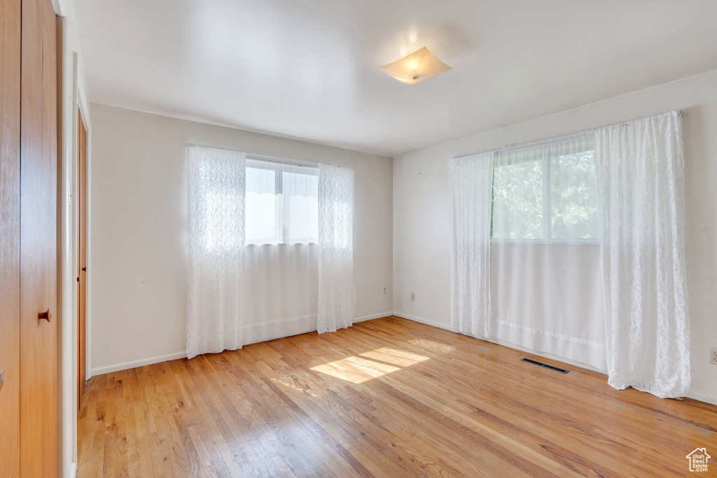 Unfurnished room with wood finished floors and baseboards