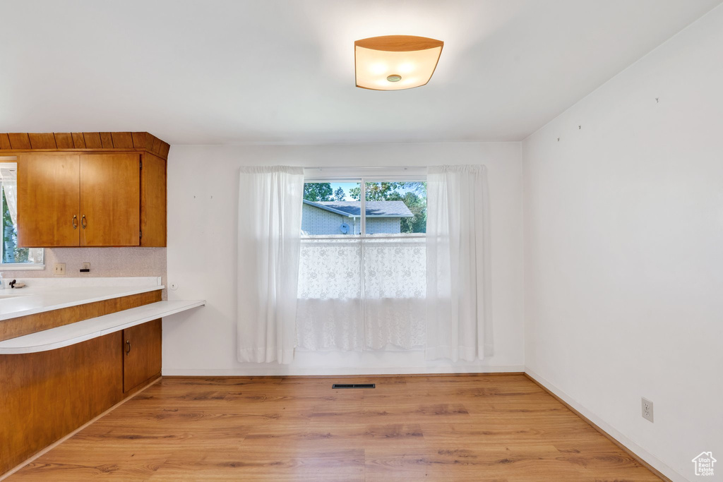 Unfurnished dining area with healthy amount of natural light and light wood-style flooring