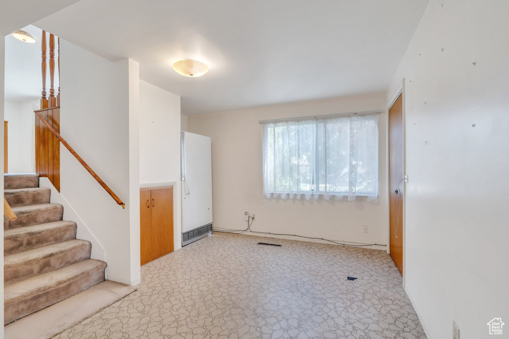 Entryway with stairway and light carpet