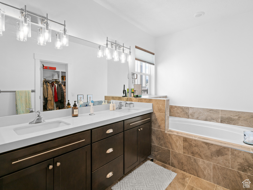 Full bathroom with a garden tub, a walk in closet, and double vanity