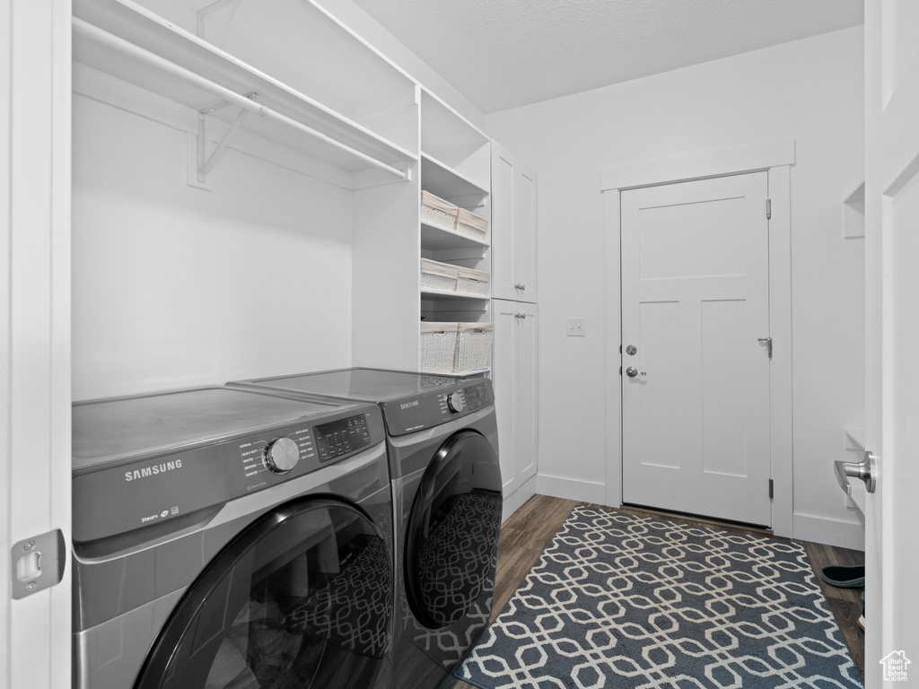 Laundry room with washer and clothes dryer, wood finished floors, and baseboards