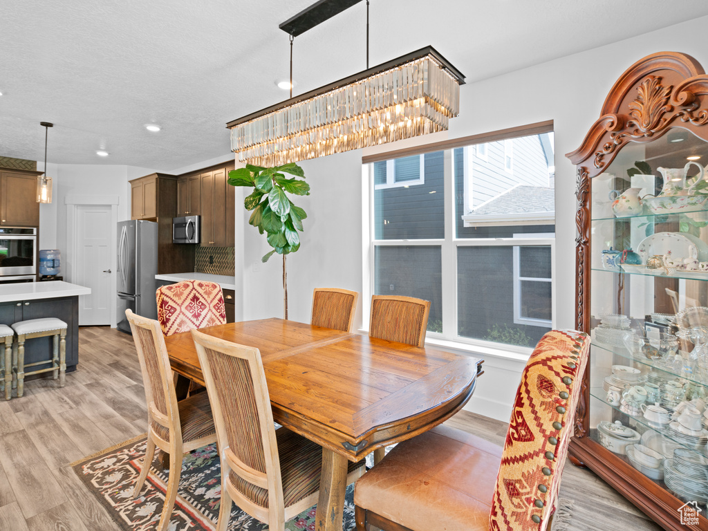 Dining space with recessed lighting and light wood-type flooring