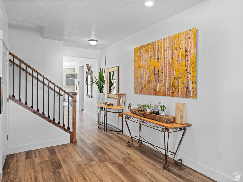 Foyer entrance with wood finished floors, stairway, baseboards, and recessed lighting