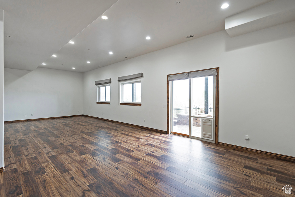 Spare room featuring dark wood-style flooring, recessed lighting, and baseboards