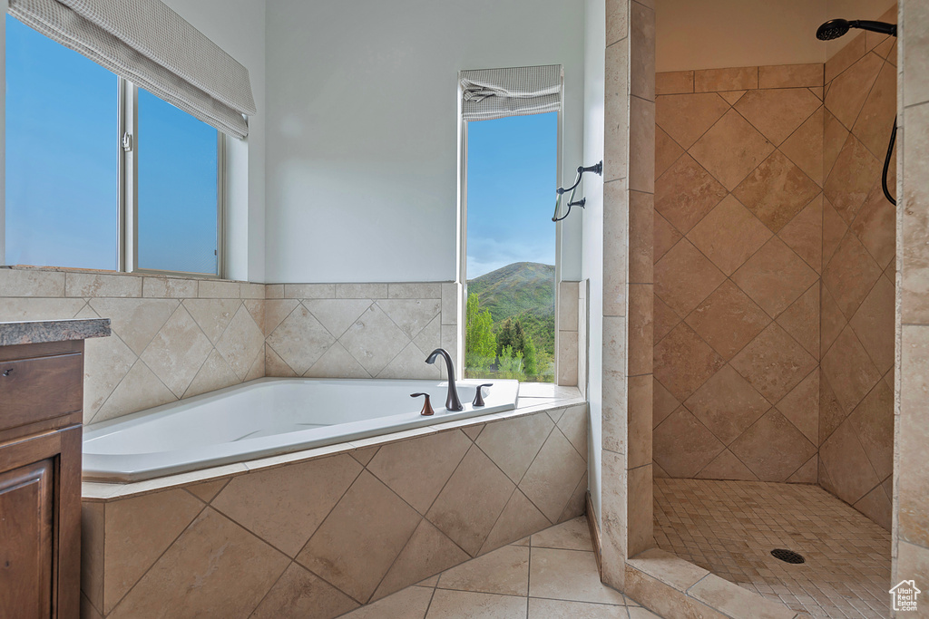 Bathroom featuring a tile shower, a bath, and tile patterned flooring