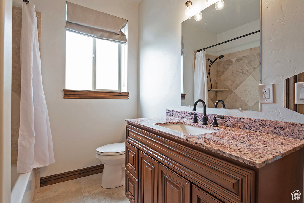 Full bathroom featuring toilet, baseboards, and vanity