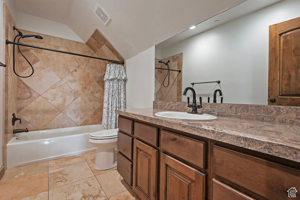 Bathroom featuring shower / tub combo with curtain, toilet, and vanity