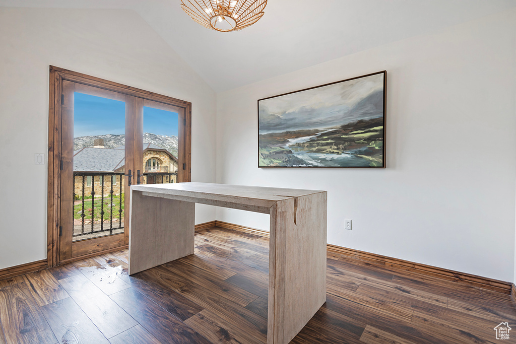 Unfurnished office with vaulted ceiling, dark wood-type flooring, a chandelier, and baseboards