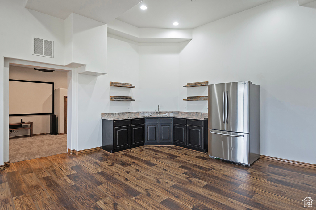 Kitchen with freestanding refrigerator, open shelves, dark wood-type flooring, recessed lighting, and baseboards