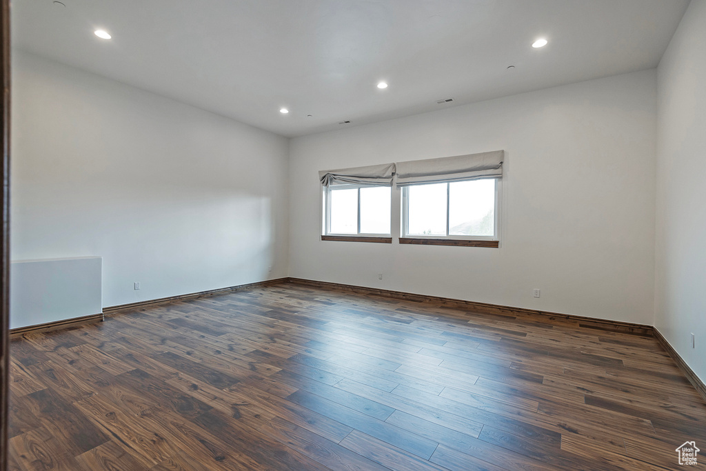 Unfurnished room with dark wood-type flooring, recessed lighting, and baseboards