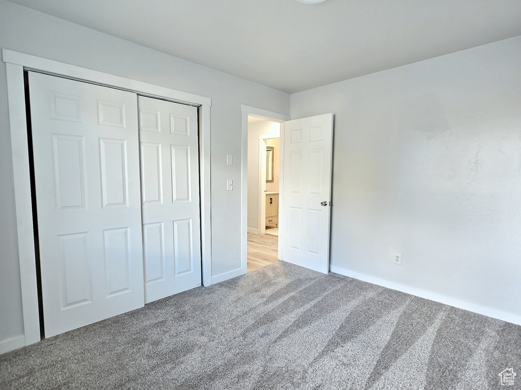 Unfurnished bedroom with carpet, baseboards, and a closet