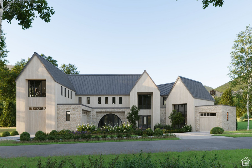 View of front of property with stone siding and metal roof