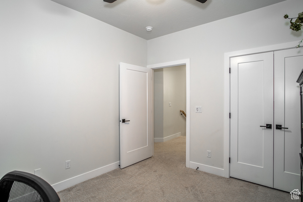 Unfurnished bedroom with light carpet, baseboards, a closet, and ceiling fan