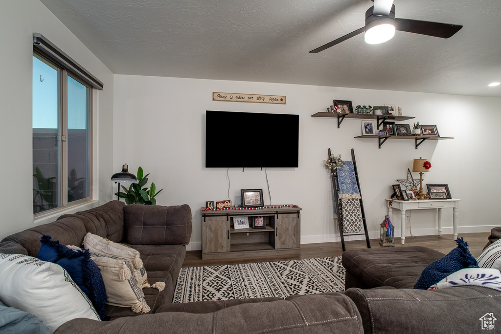 Living room with wood finished floors, baseboards, and ceiling fan