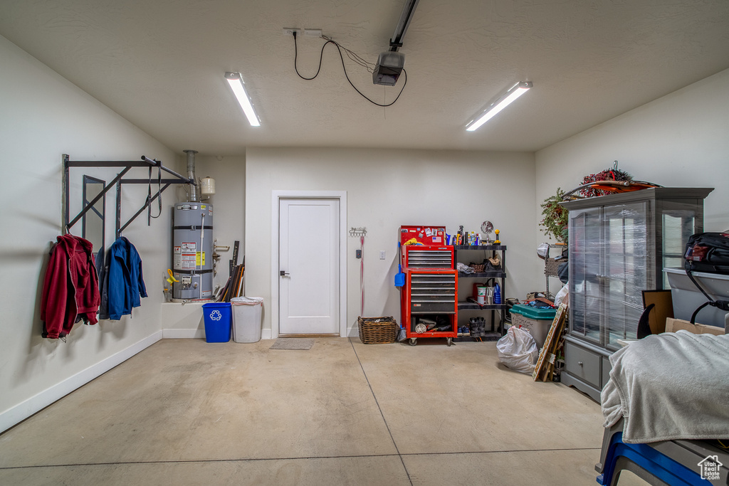 Garage featuring water heater and baseboards