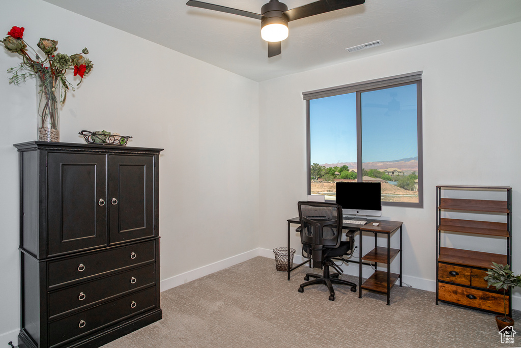 Home office featuring baseboards, ceiling fan, and light colored carpet