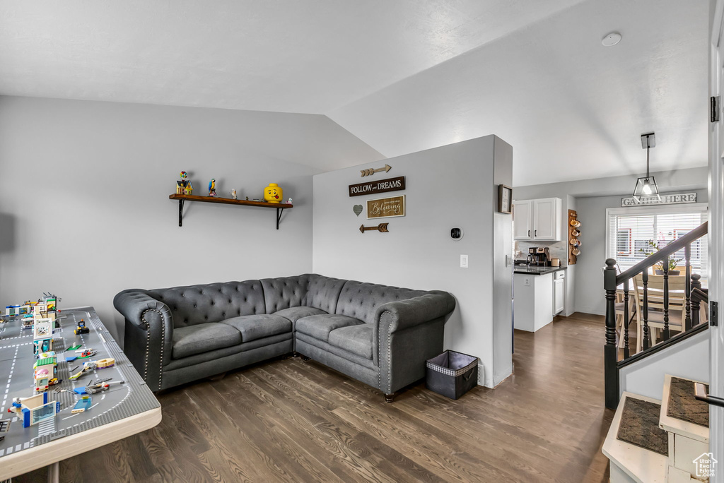 Living area with dark wood-style floors and vaulted ceiling