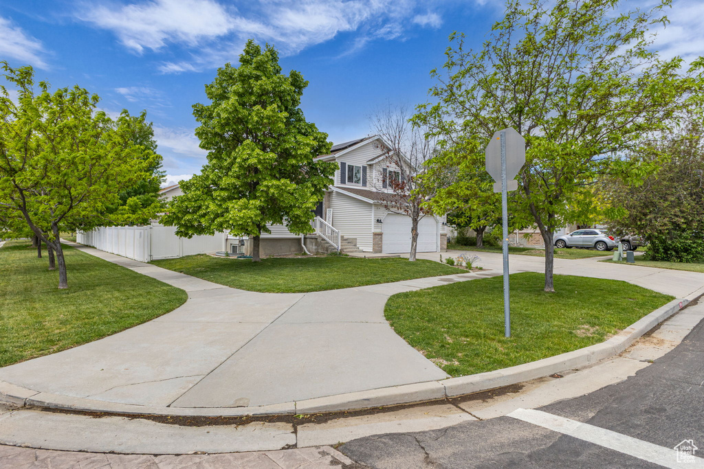 Obstructed view of property featuring an attached garage, roof mounted solar panels, and driveway