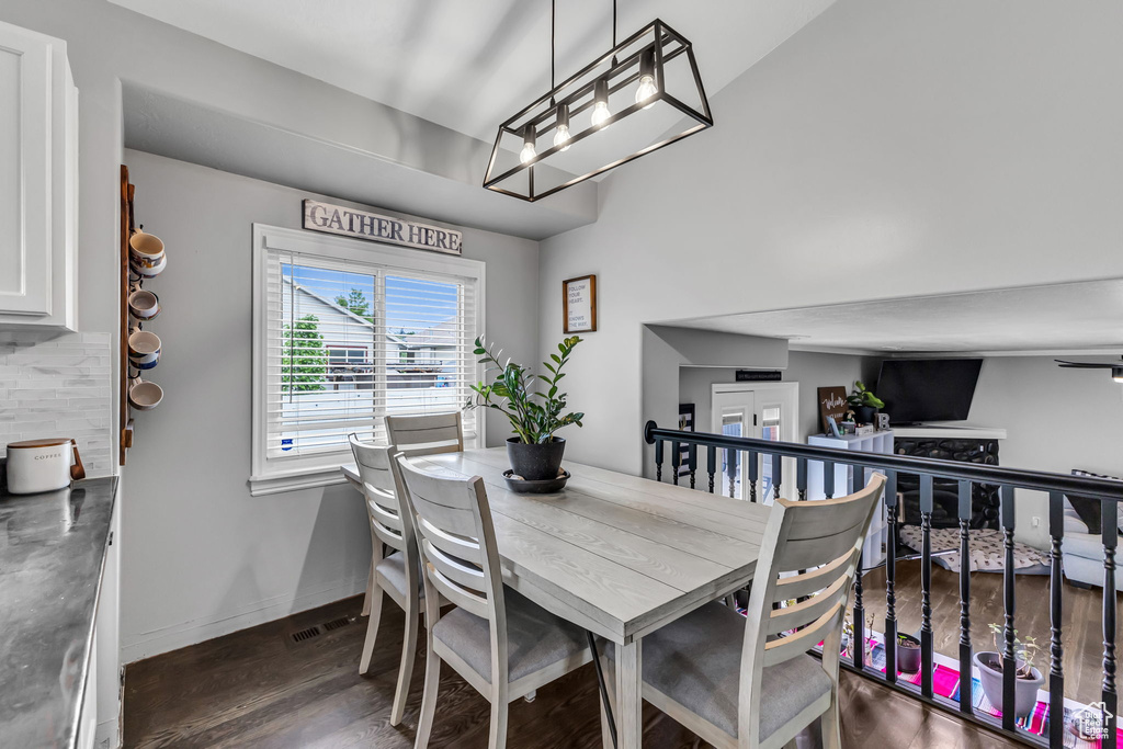 Dining room featuring wood finished floors, baseboards, and a chandelier