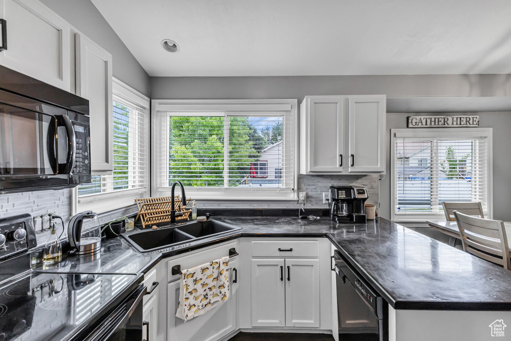Kitchen with black appliances, a sink, healthy amount of natural light, and backsplash