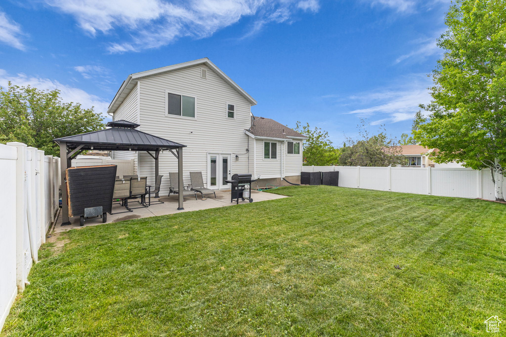 Rear view of property featuring a gazebo and a patio area