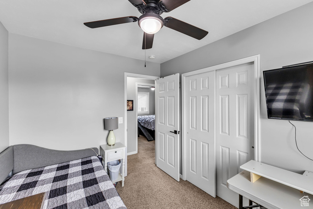 Carpeted bedroom with a closet and a ceiling fan