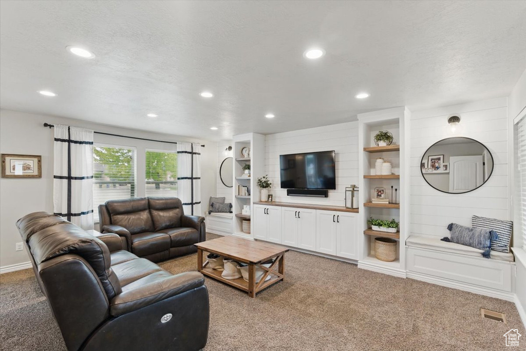 Living room with light colored carpet and recessed lighting
