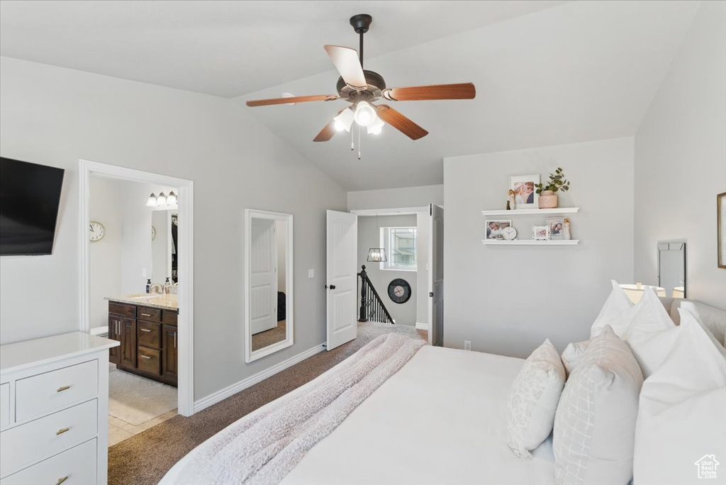 Bedroom featuring lofted ceiling, light colored carpet, a sink, ceiling fan, and baseboards