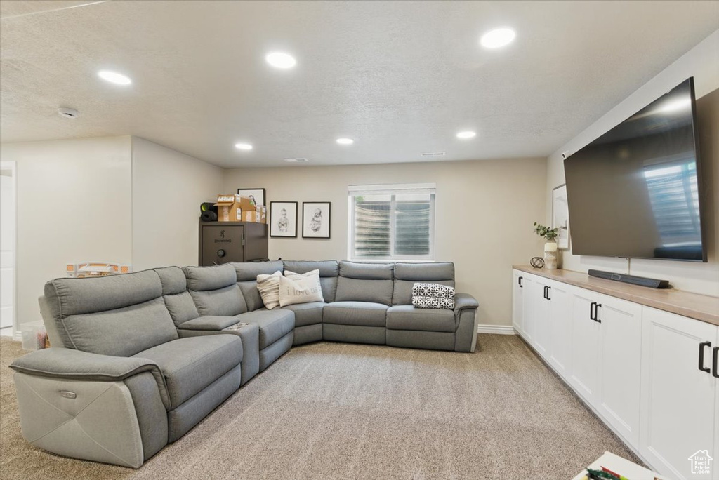 Living area with light colored carpet, recessed lighting, and baseboards