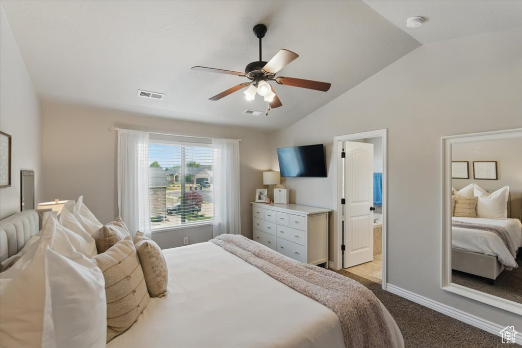 Bedroom featuring carpet floors, lofted ceiling, a ceiling fan, baseboards, and ensuite bath