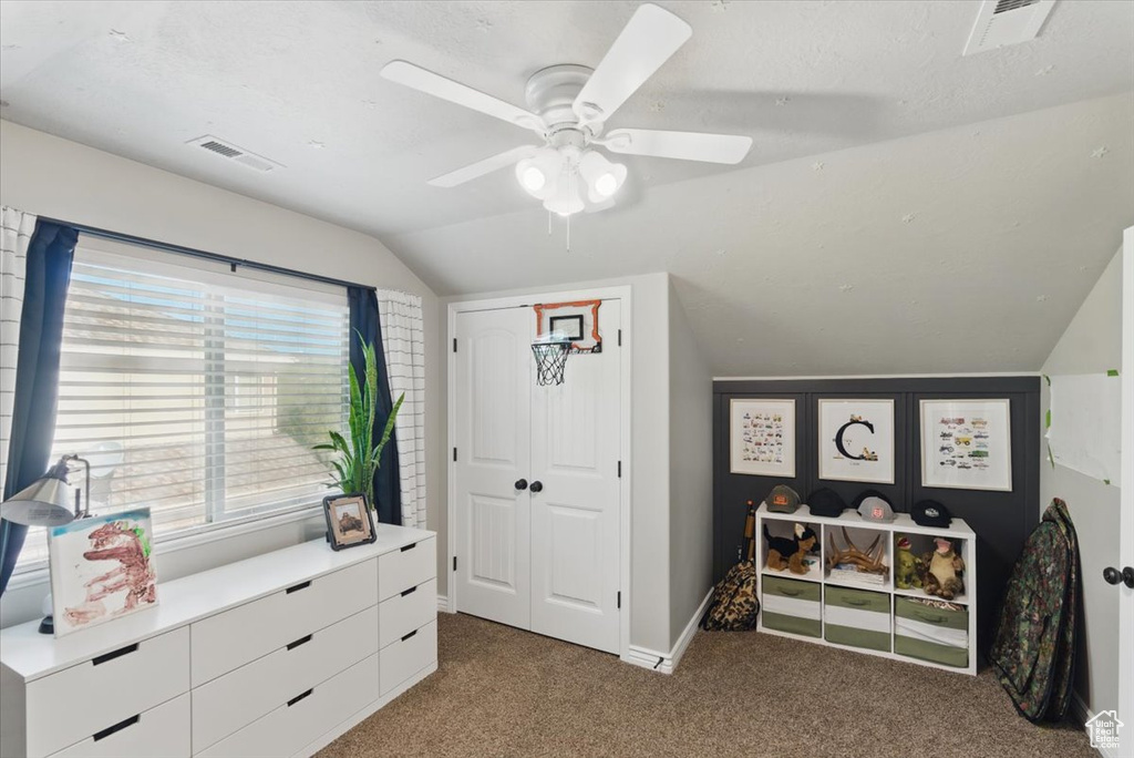 Bedroom featuring vaulted ceiling, carpet, baseboards, a ceiling fan, and a closet