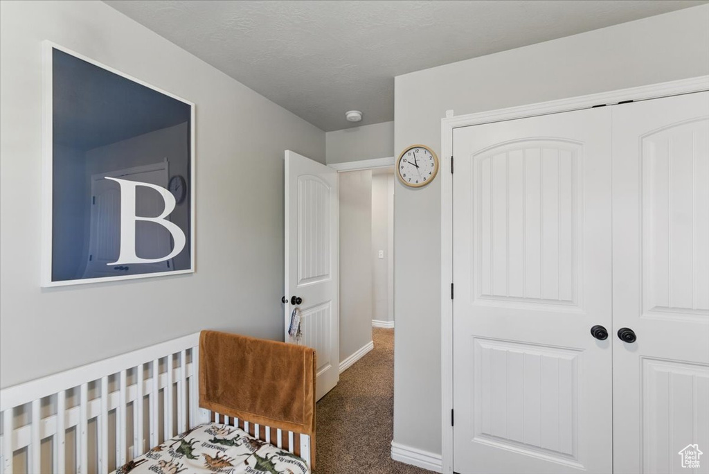 Bedroom with a closet, carpet flooring, and baseboards