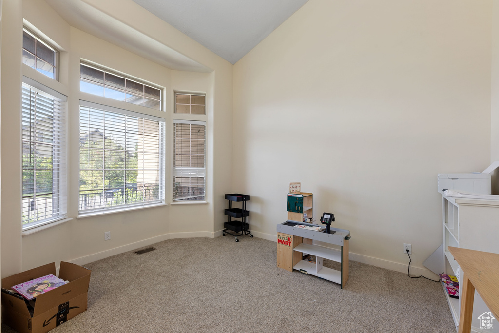 Miscellaneous room featuring carpet floors, a desk, lofted ceiling, and baseboards