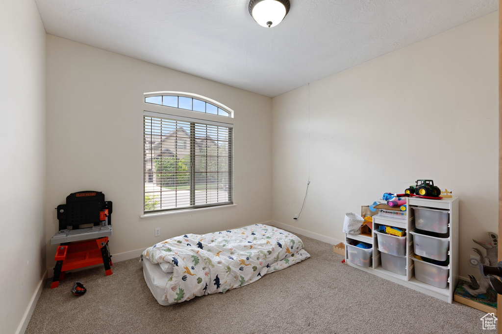 Bedroom featuring carpet floors and baseboards