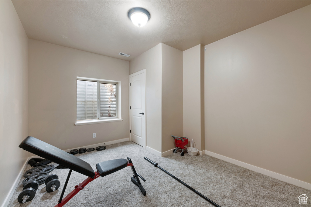Exercise area featuring carpet floors and baseboards
