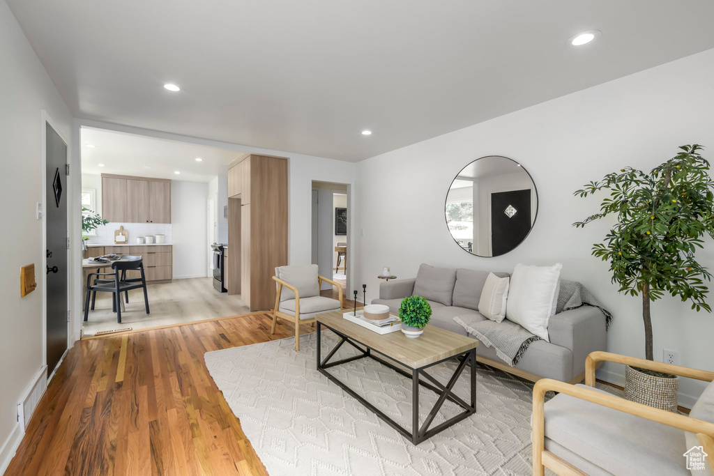 Living room with light wood-style floors and recessed lighting