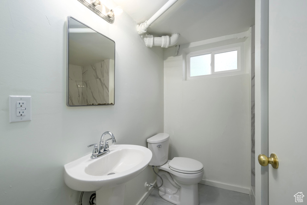 Bathroom with a sink, toilet, and baseboards